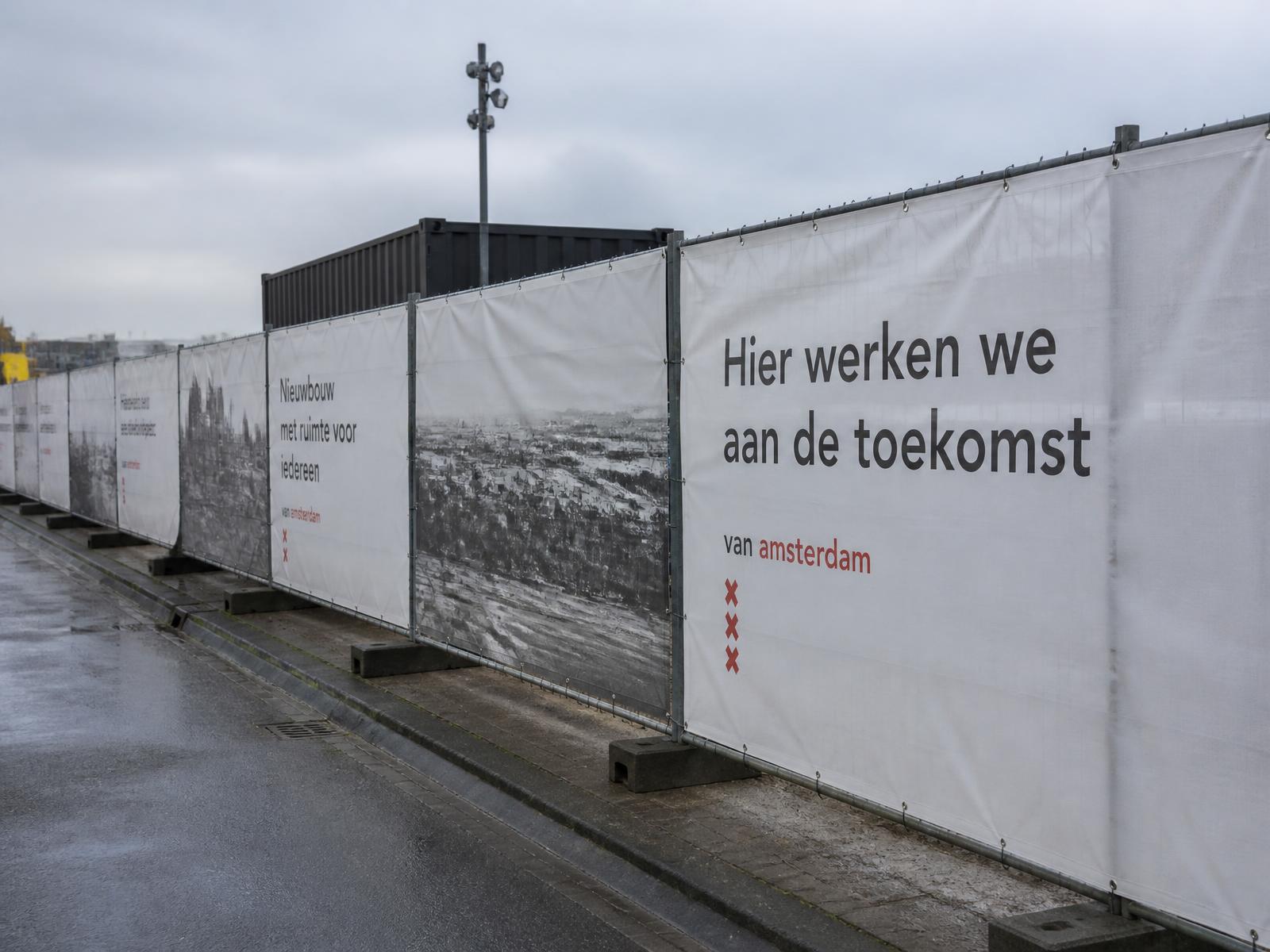 Bouwhekken met bedrukte doeken langs een wegwerkzaamheden-project